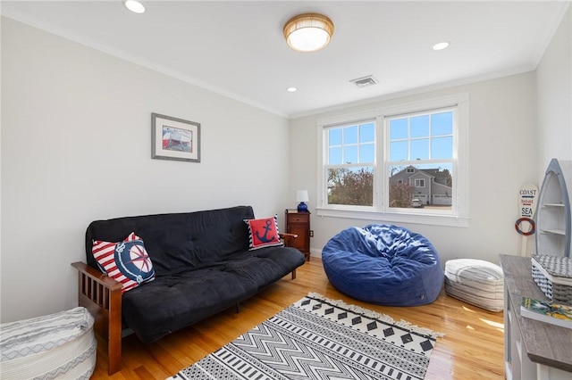 living room with wood finished floors, visible vents, recessed lighting, and ornamental molding