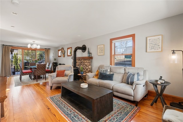 living area with recessed lighting, light wood-type flooring, and a wood stove