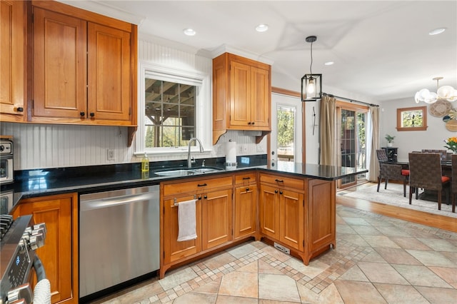 kitchen with stainless steel appliances, a sink, brown cabinetry, and an inviting chandelier