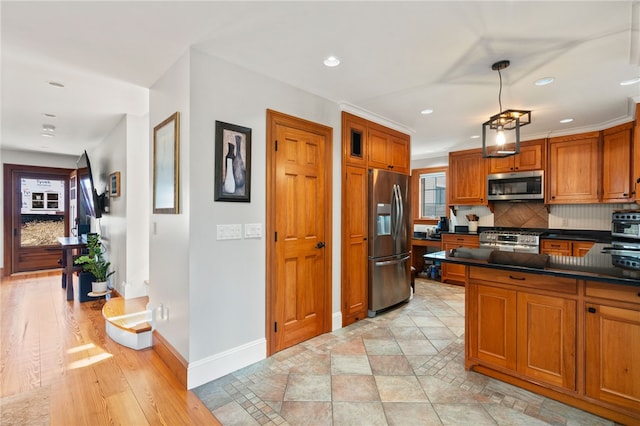 kitchen with dark countertops, baseboards, recessed lighting, brown cabinetry, and appliances with stainless steel finishes