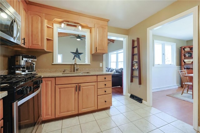 kitchen with light brown cabinets, a sink, a wealth of natural light, appliances with stainless steel finishes, and ceiling fan