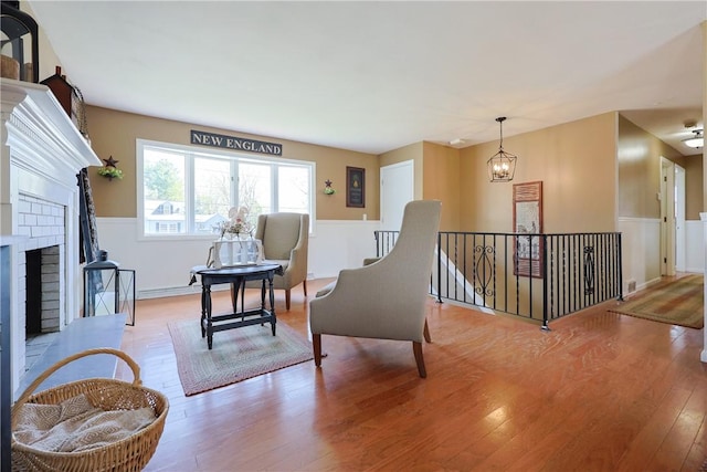 living area featuring an upstairs landing, light wood-style floors, and a fireplace