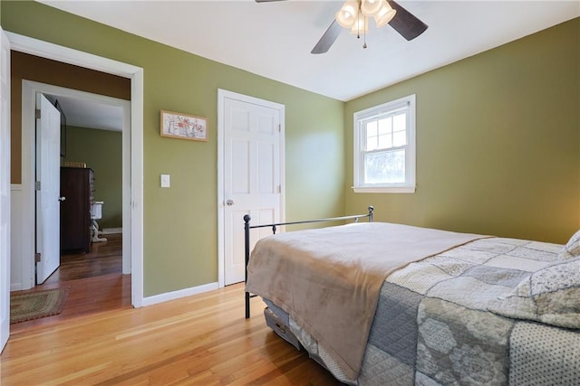 bedroom with light wood-style flooring, baseboards, and a ceiling fan