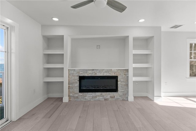 unfurnished living room featuring baseboards, built in features, wood finished floors, and visible vents