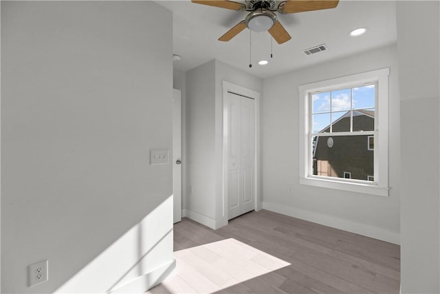 unfurnished bedroom with recessed lighting, light wood finished floors, visible vents, a closet, and baseboards