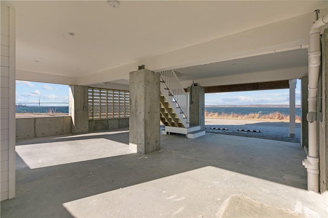 view of patio / terrace with stairs, a water view, and a carport