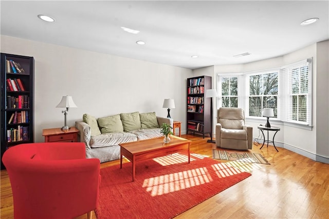 living area featuring baseboards, wood finished floors, visible vents, and recessed lighting