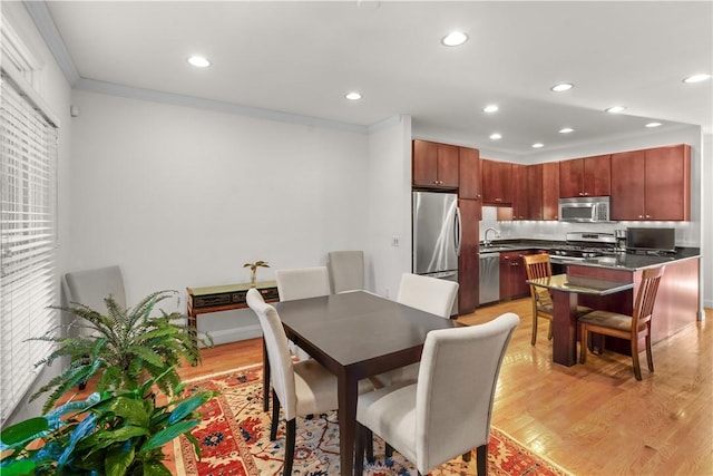 dining room with light wood-type flooring, recessed lighting, and crown molding