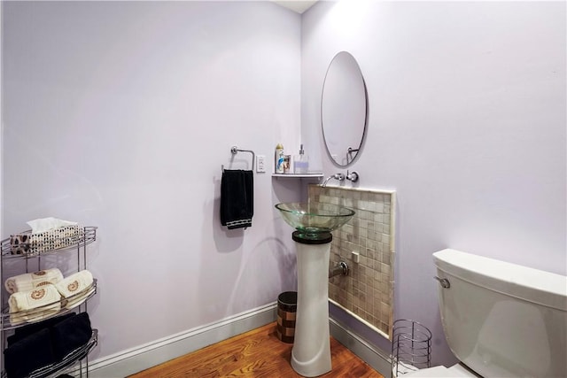 bathroom with wood finished floors, toilet, and baseboards