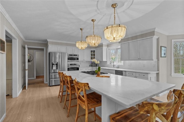 10 David Ct, East Greenwich, RI 02818 - kitchen with stainless steel appliances, light wood-type flooring, a chandelier, and decorative backsplash