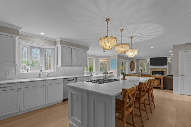 10 David Ct, East Greenwich, RI 02818 - kitchen featuring tasteful backsplash, a chandelier, appliances with stainless steel finishes, light wood finished floors, and a sink