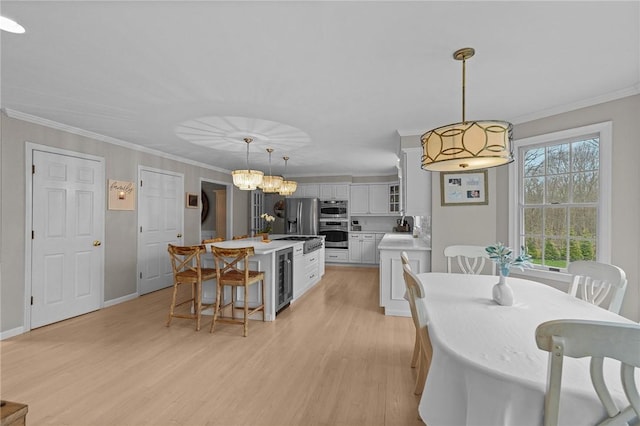 10 David Ct, East Greenwich, RI 02818 - dining area with light wood-type flooring, baseboards, beverage cooler, and ornamental molding