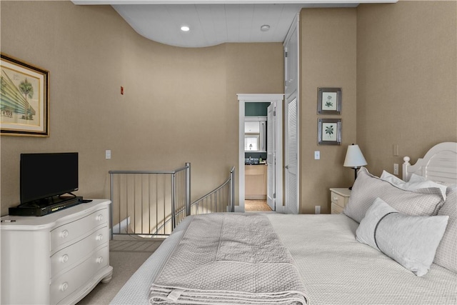bedroom featuring light colored carpet and ensuite bathroom