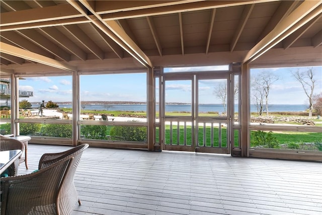 sunroom with a deck with water view
