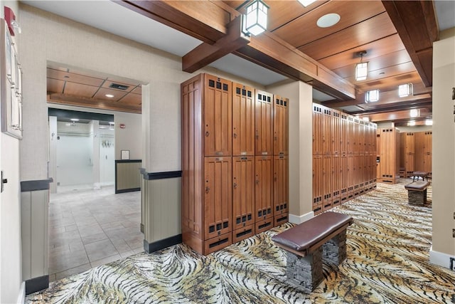 interior space featuring baseboards, beam ceiling, wood ceiling, and visible vents