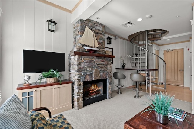 living room featuring visible vents, recessed lighting, stairs, a stone fireplace, and ornamental molding