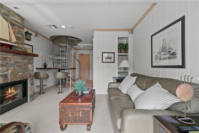 living room featuring stairway, visible vents, carpet flooring, and a stone fireplace