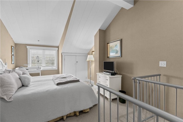 carpeted bedroom featuring lofted ceiling with beams