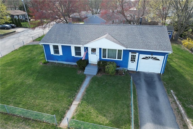 view of front of property featuring a front yard, roof with shingles, a garage, fence, and aphalt driveway