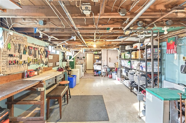 below grade area with a workshop area, tile patterned floors, and washer and dryer