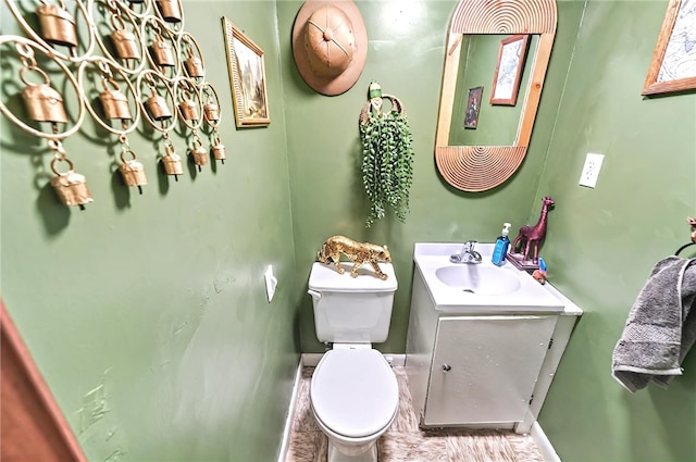 bathroom with vanity, baseboards, and toilet