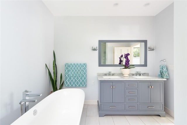 29 Reliance Dr, Bristol, RI 02809 - bathroom featuring a freestanding bath, double vanity, baseboards, and a sink