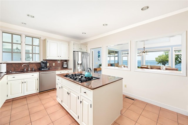 29 Reliance Dr, Bristol, RI 02809 - kitchen with a center island, a sink, light tile patterned flooring, backsplash, and appliances with stainless steel finishes