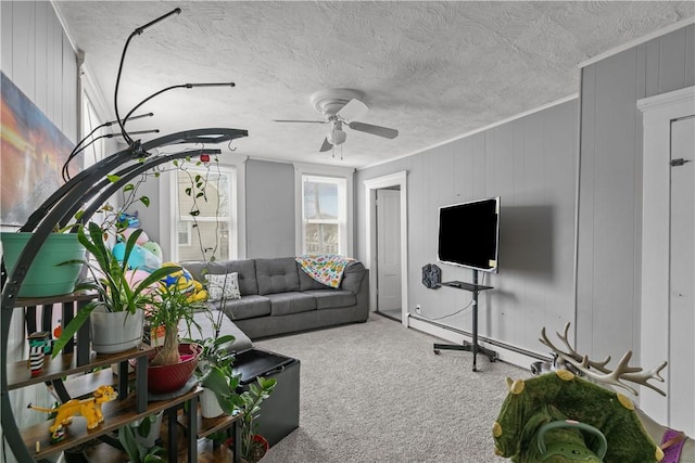 carpeted living room with a textured ceiling, ornamental molding, and ceiling fan