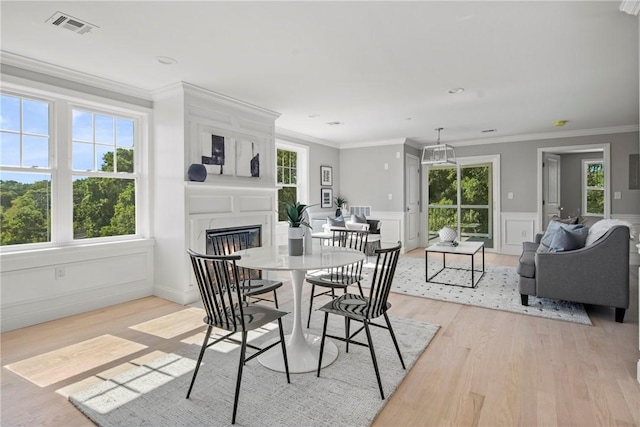 0 Greenwich Blvd Unit 203, East Greenwich, RI 02818 - dining area with light wood-style flooring, a fireplace, crown molding, and a wainscoted wall