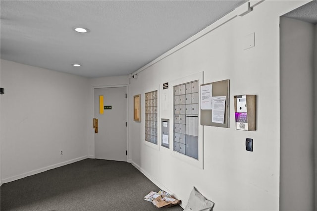 interior space with mail area, baseboards, dark carpet, and recessed lighting
