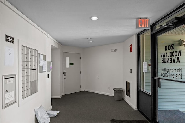 hall featuring baseboards, dark colored carpet, mail area, and recessed lighting
