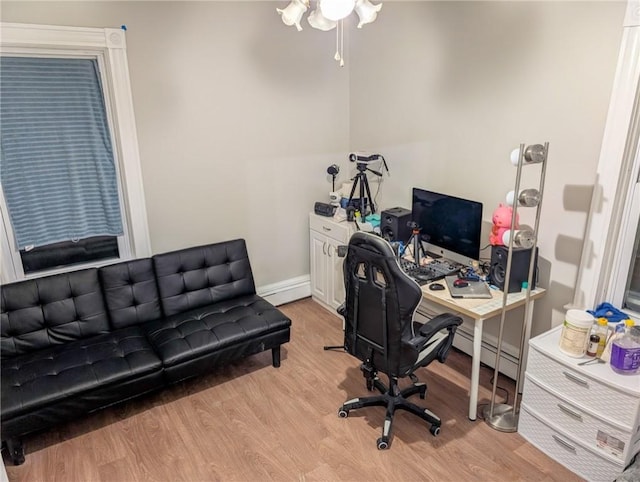 office featuring baseboard heating, baseboards, and light wood-style floors