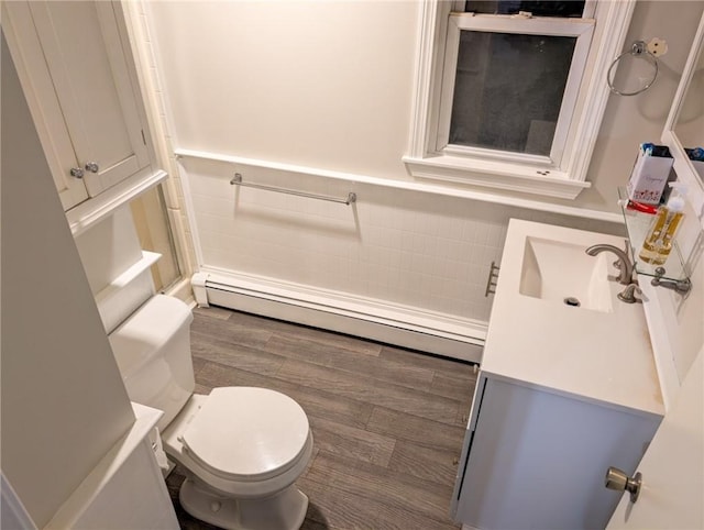 bathroom with baseboard heating, toilet, and vanity