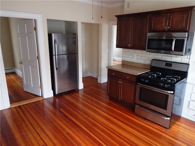 kitchen with baseboard heating, tasteful backsplash, crown molding, baseboards, and appliances with stainless steel finishes