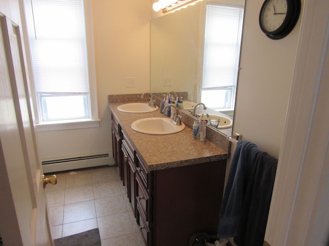 full bath featuring double vanity, a healthy amount of sunlight, baseboard heating, and a sink