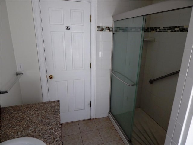 bathroom featuring tile patterned floors, a shower stall, and toilet
