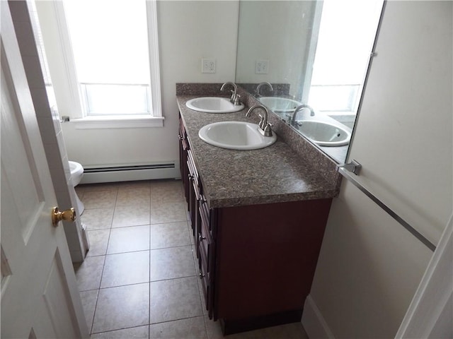 full bathroom with a baseboard heating unit and a sink