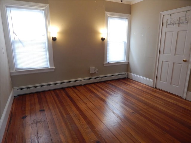 spare room with baseboards, hardwood / wood-style flooring, and baseboard heating