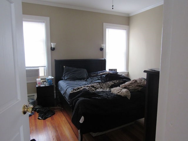 bedroom featuring wood finished floors, crown molding, and cooling unit