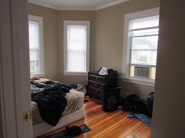 bedroom featuring crown molding, light wood-style floors, and cooling unit