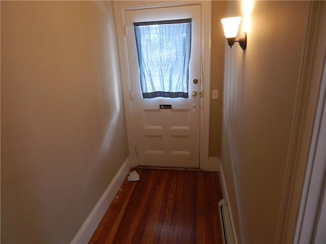 doorway to outside featuring baseboard heating, baseboards, and dark wood-style floors