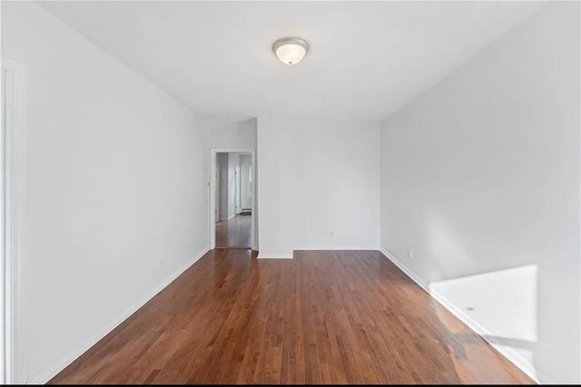empty room featuring baseboards and wood finished floors