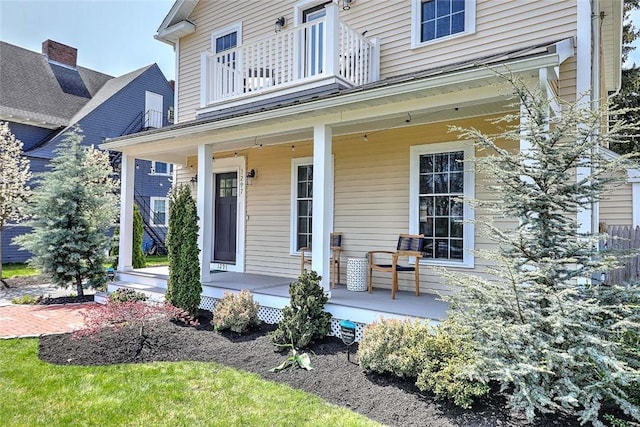 entrance to property featuring a porch and a balcony