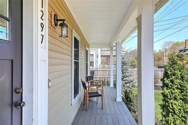 deck featuring fence and covered porch