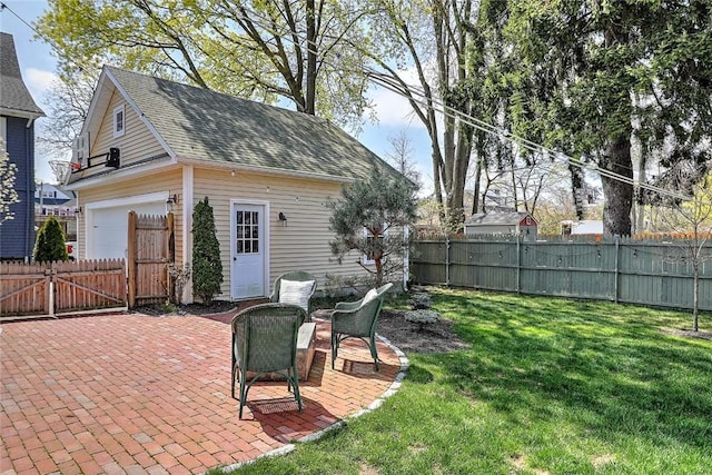 exterior space featuring a fenced backyard, a gate, a patio area, and a garage