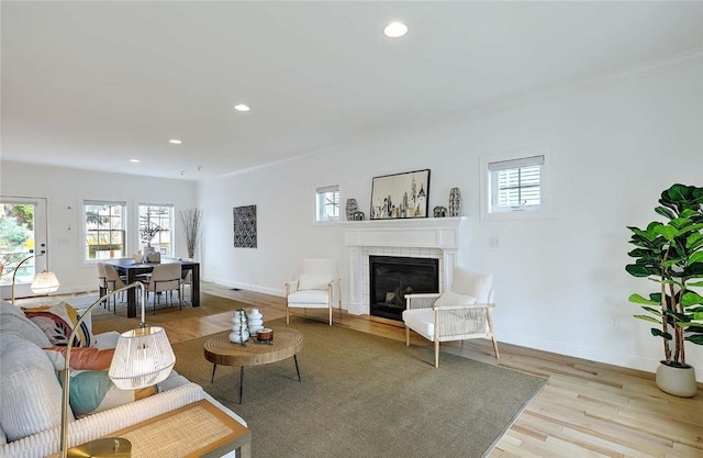 living area with recessed lighting, a wealth of natural light, and a tile fireplace