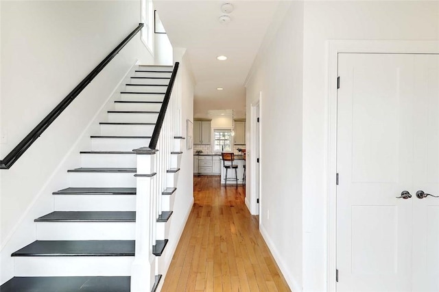 stairs featuring wood-type flooring, recessed lighting, and baseboards
