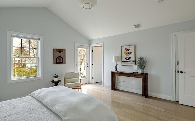 bedroom with baseboards, visible vents, light wood finished floors, and lofted ceiling