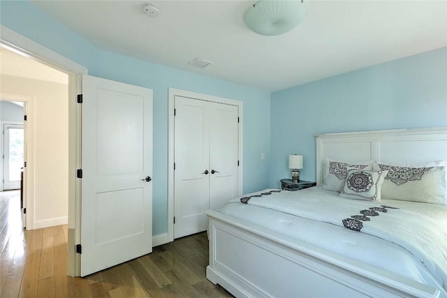 bedroom with a closet, baseboards, and wood finished floors