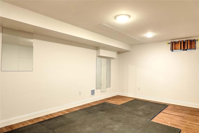finished basement featuring baseboards, wood finished floors, and visible vents